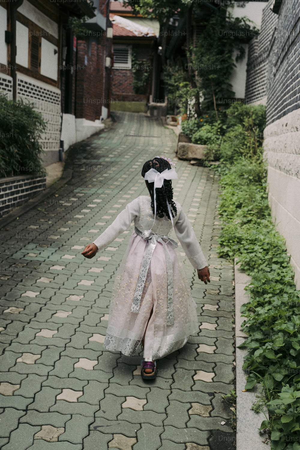通りを歩く白いドレスを着た少女