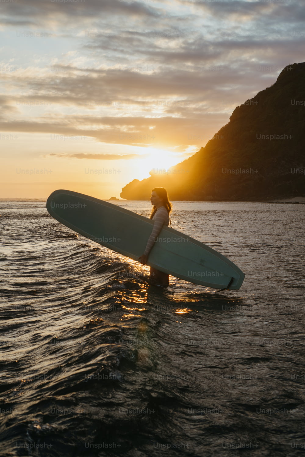una persona che tiene una tavola da surf nell'acqua