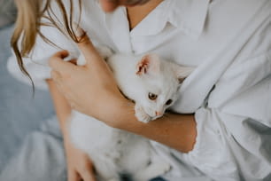 Une femme tenant un chat blanc dans ses bras