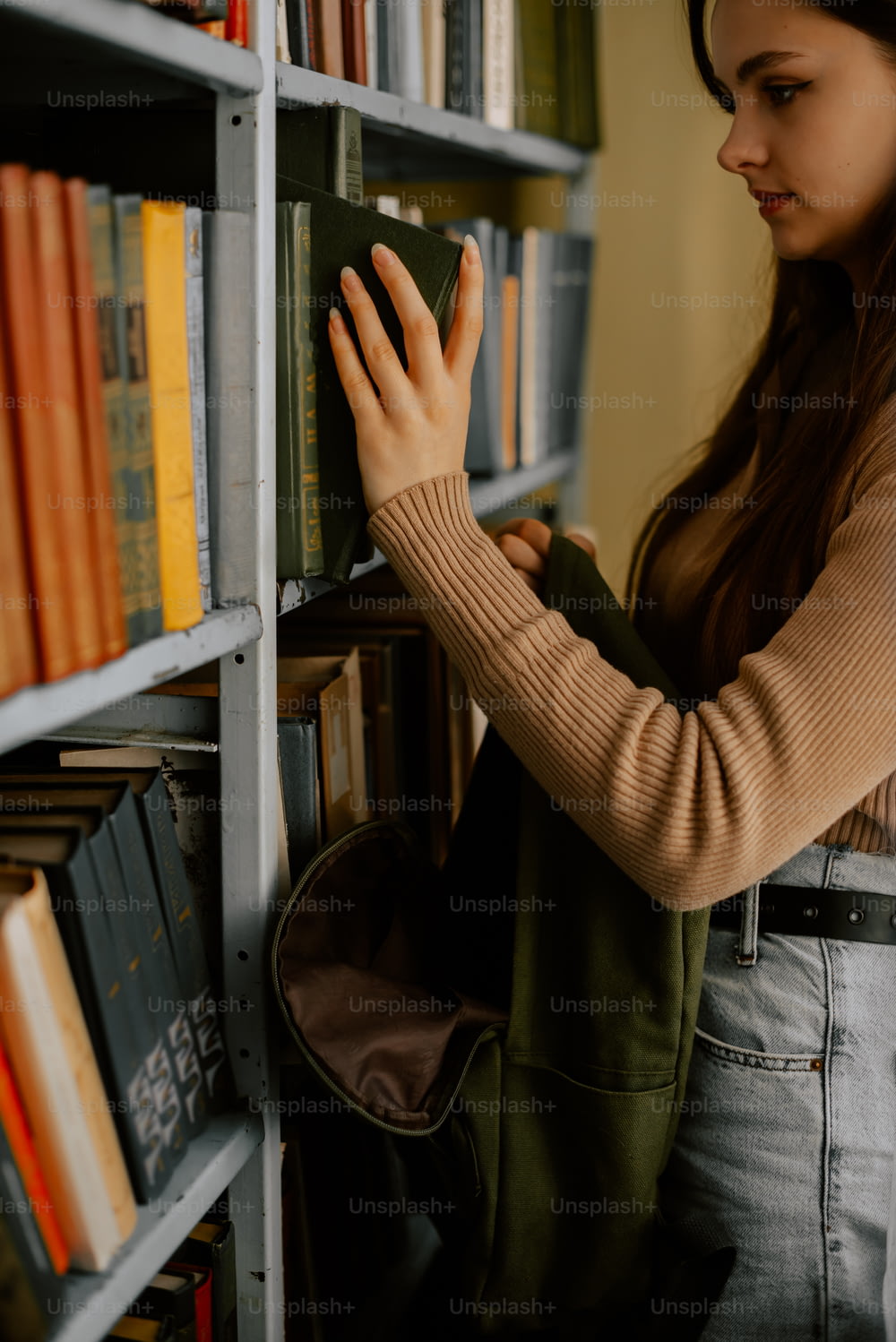 Una donna sta guardando i libri su uno scaffale di libri