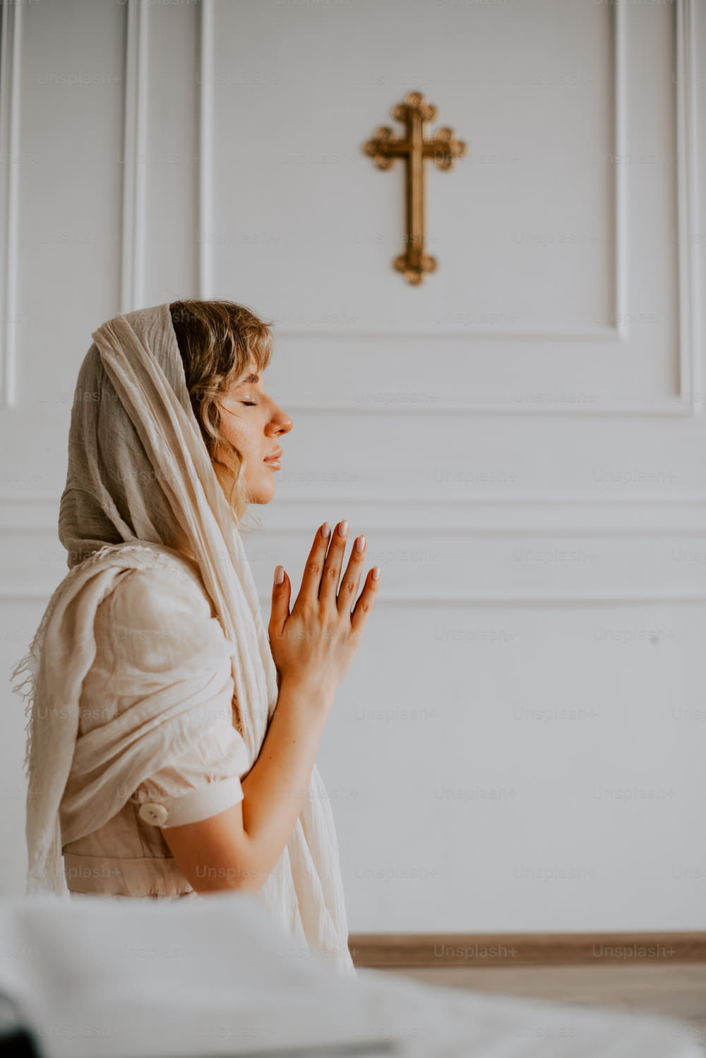 a woman in a white robe is praying