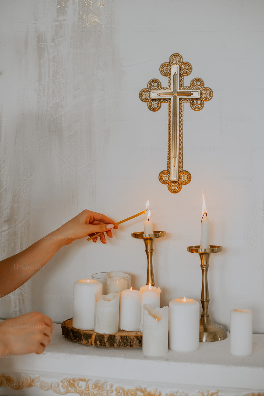 a person lighting candles in front of a cross