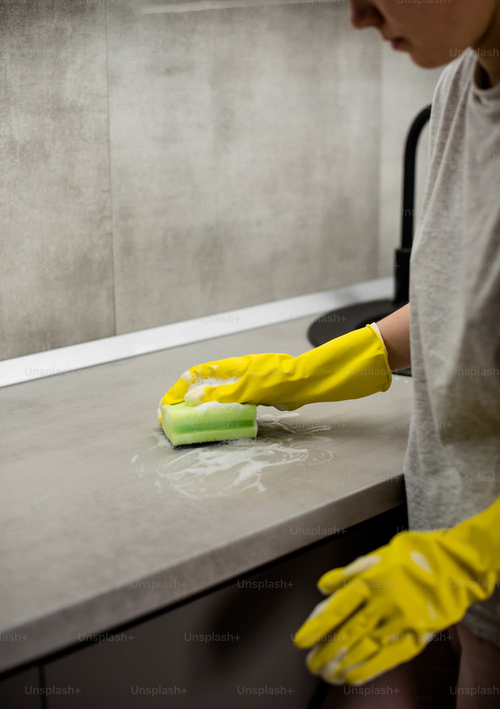 a person in yellow gloves cleaning a counter