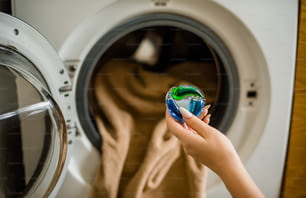 Une femme tient un jouet devant une machine à laver
