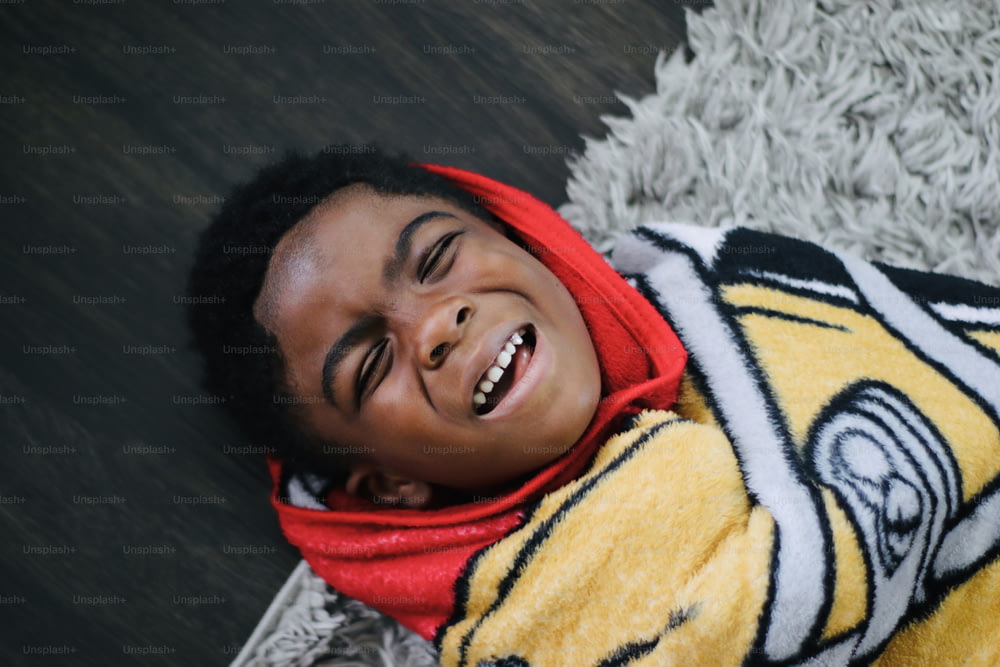 Un ragazzo sorride mentre è sdraiato sul pavimento