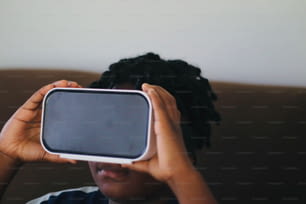 una persona sosteniendo un teléfono celular en su cara
