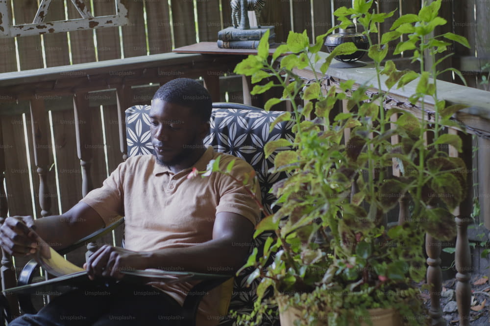 Un uomo seduto su una sedia con una pianta di fronte a lui