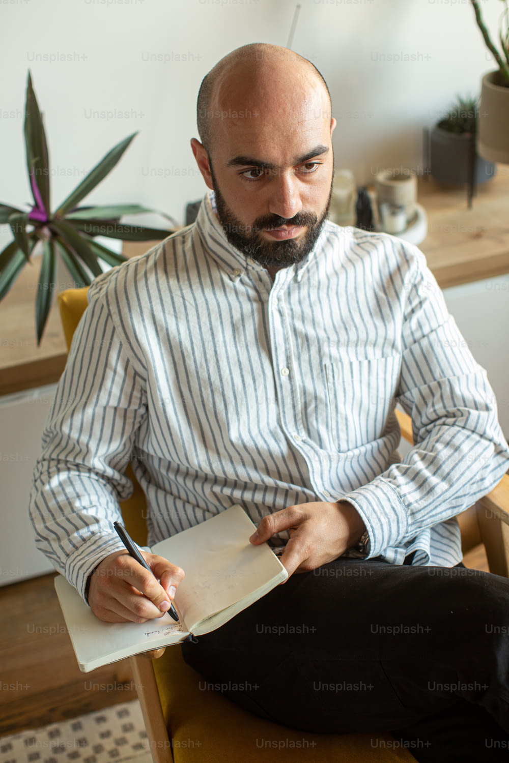 a man sitting on a chair writing on a piece of paper