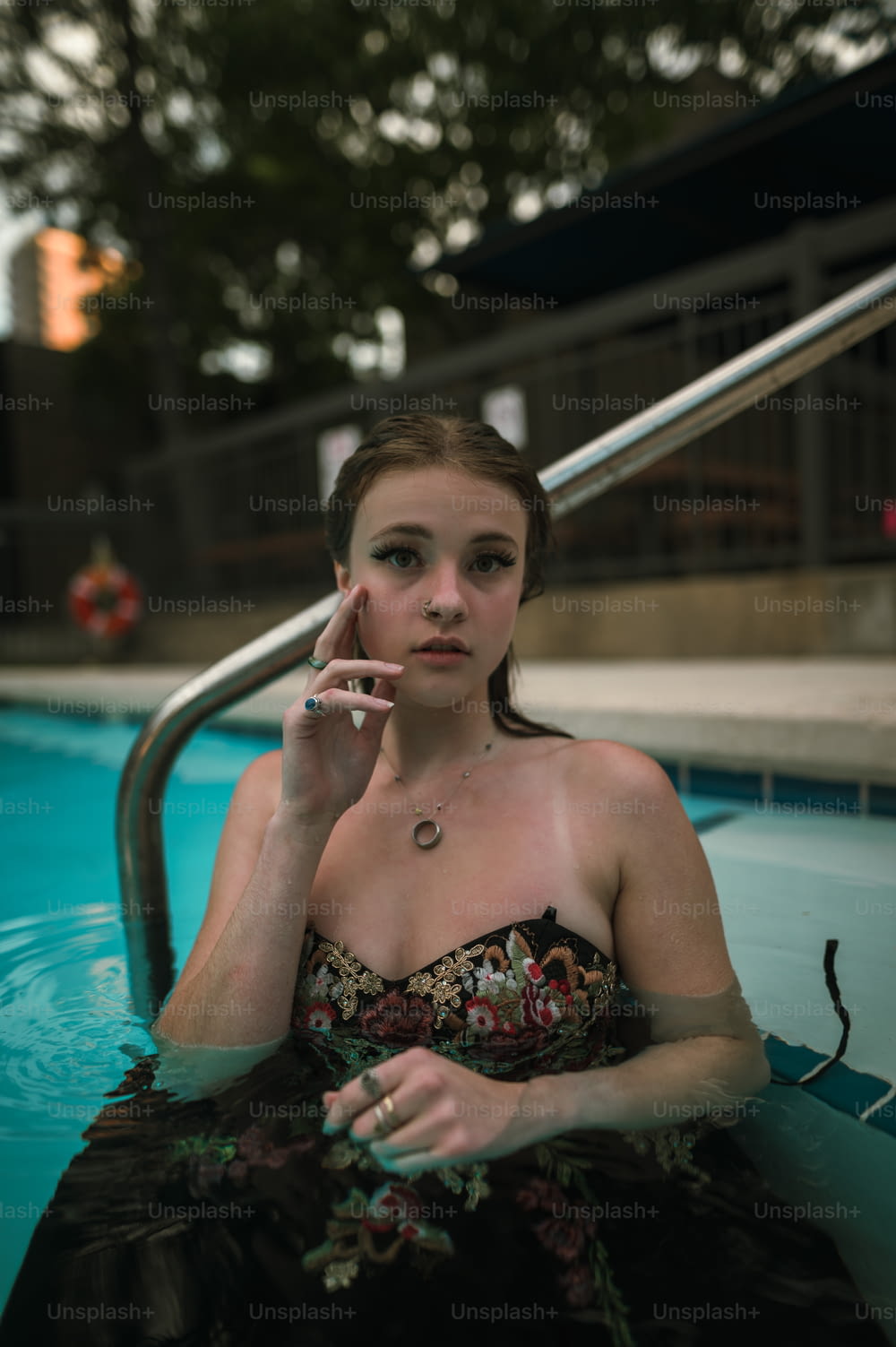 a woman sitting in a pool smoking a cigarette