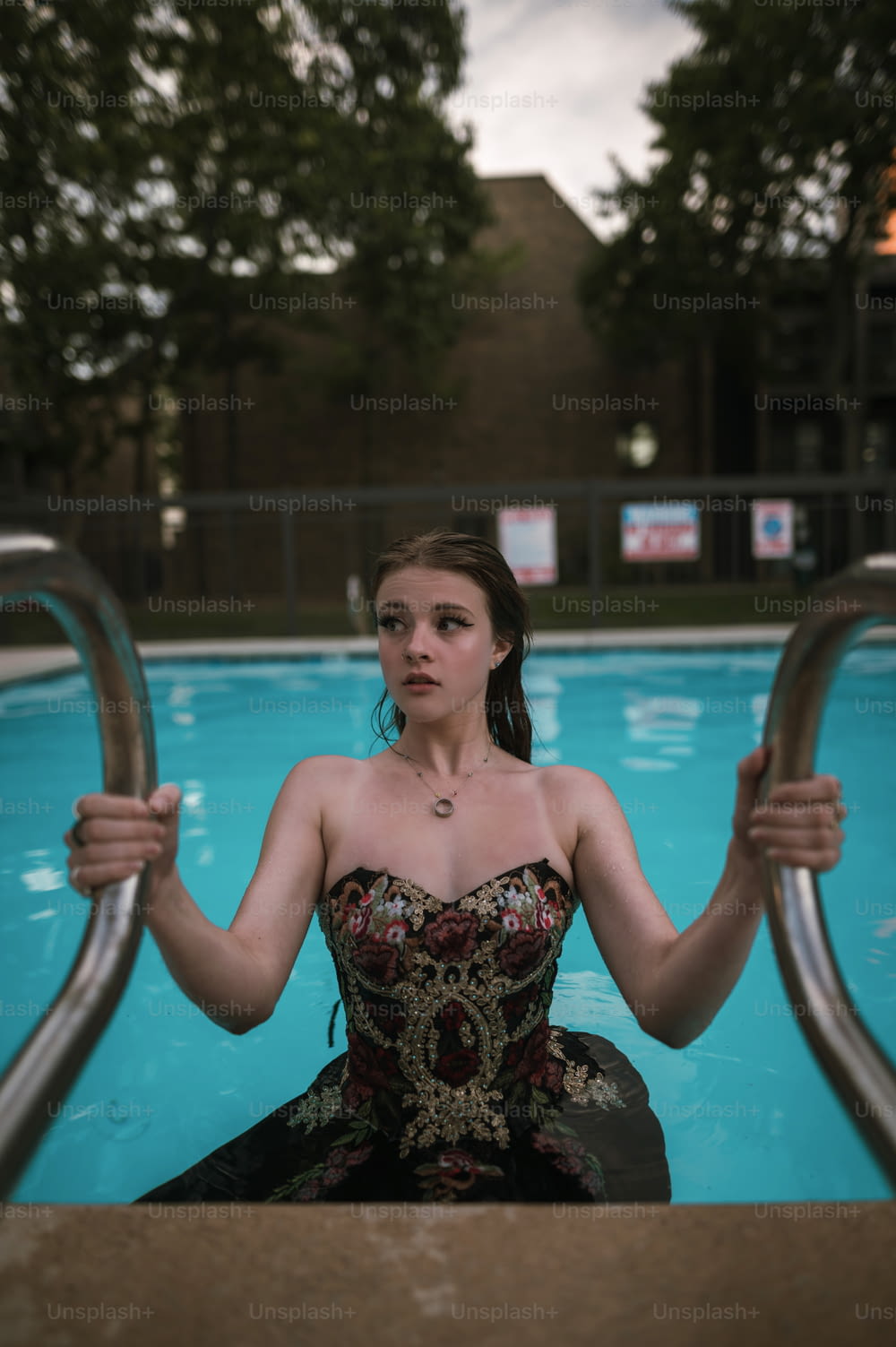 a woman in a dress sitting in a pool