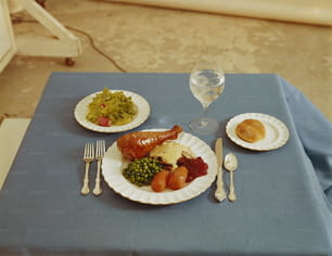 a table topped with plates of food and a glass of wine