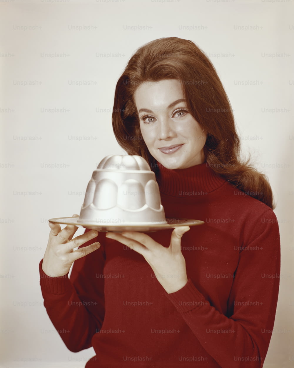 una donna che tiene un piatto con una torta su di esso