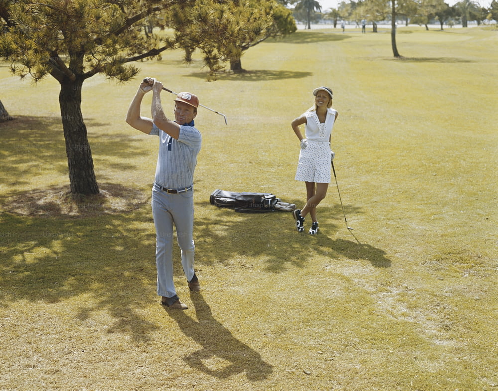 들판에서 골프를 치는 남자와 여자