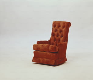 une chaise marron posée sur un sol blanc