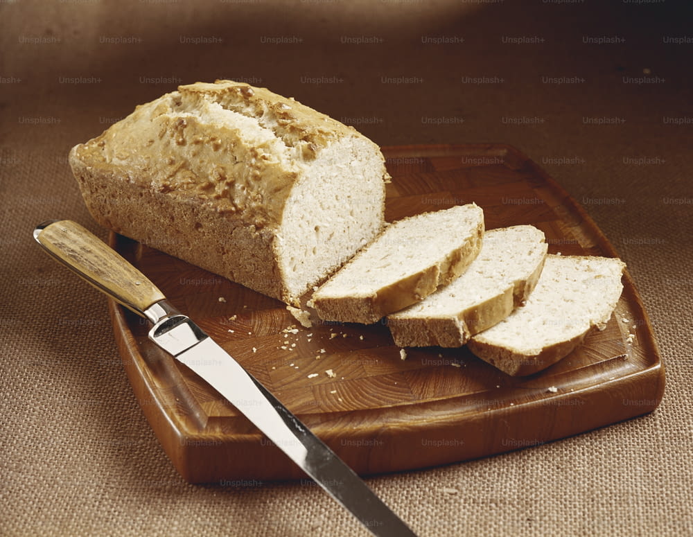a loaf of bread sitting on top of a cutting board next to a knife