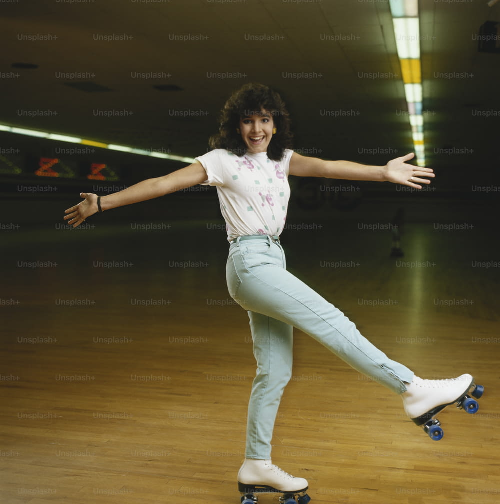 a woman riding a skateboard on top of a wooden floor