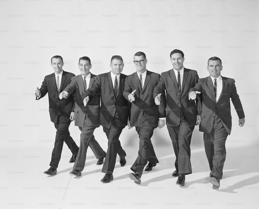 スーツとネクタイを着た男性のグループが一緒に歩く