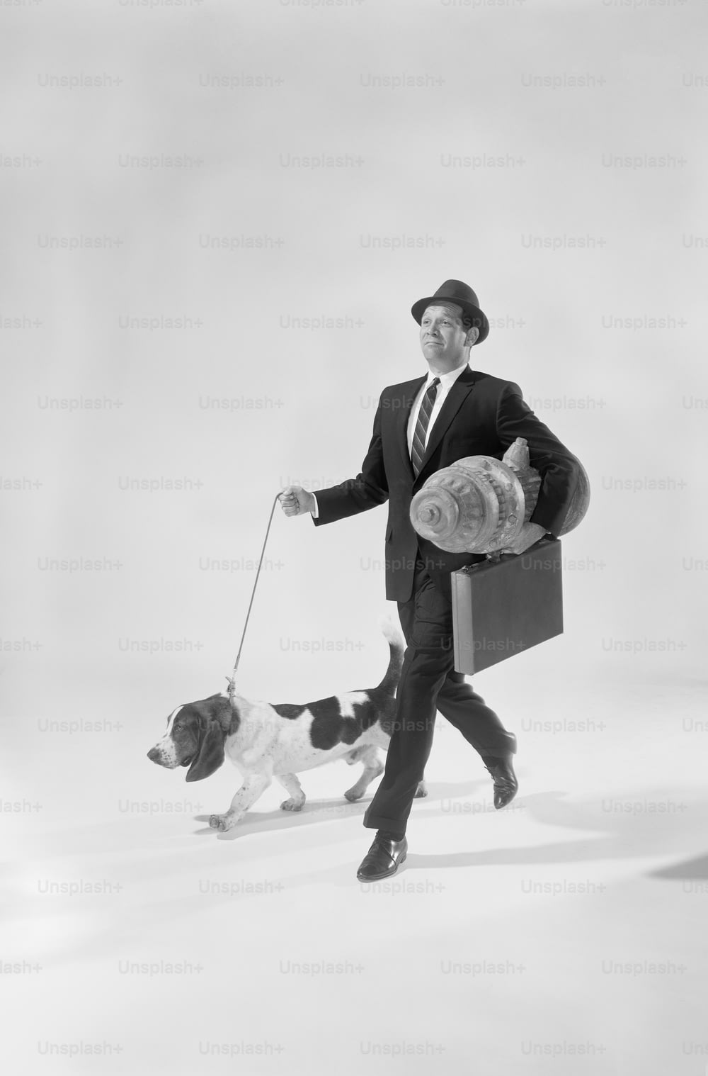 um homem de terno e gravata passeando com um cachorro