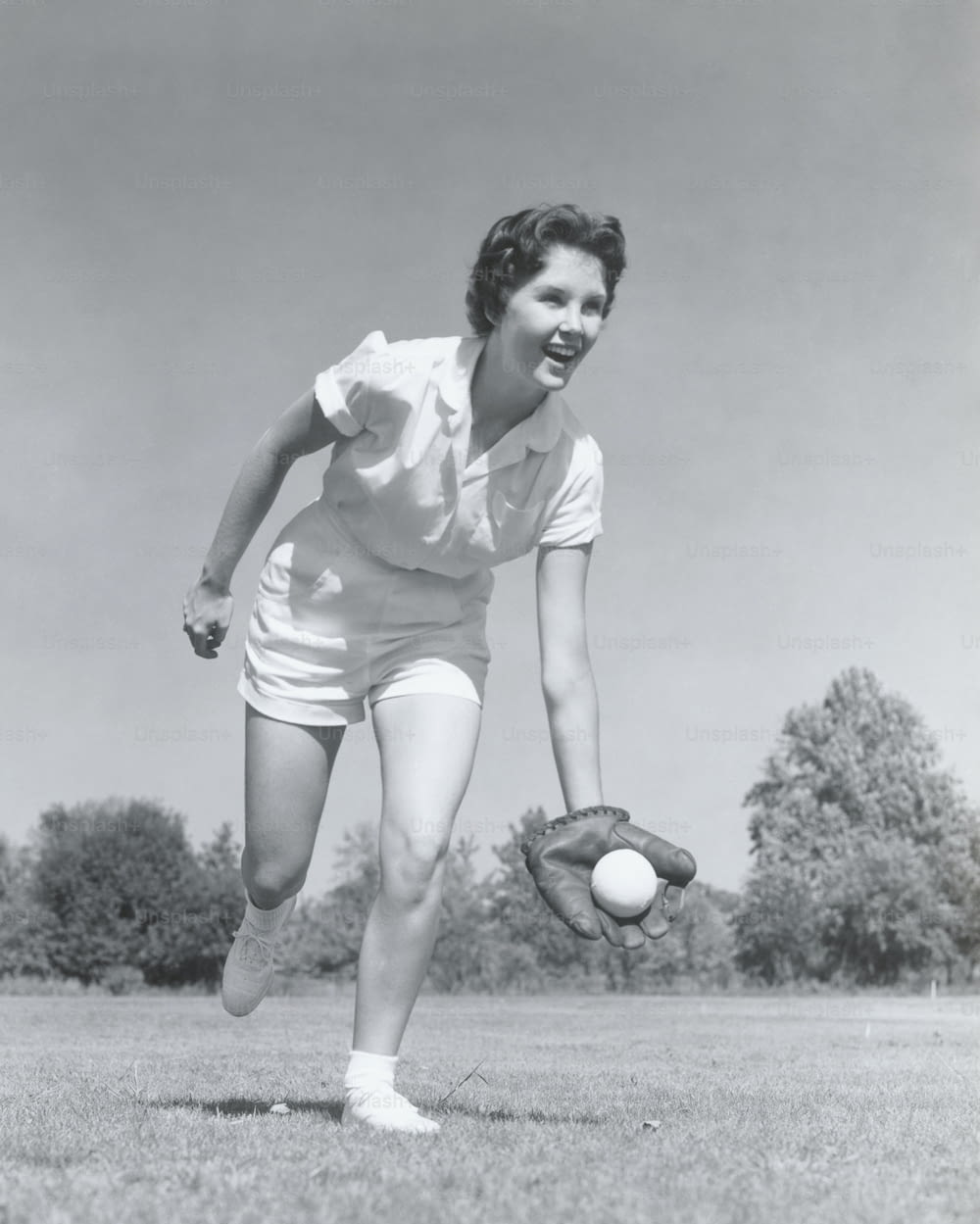 アメリカ合衆国 - 1950年代頃:グローブをはめて野球をキャッチする若い女性。