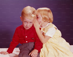 미국 - 1950년대경: 소년의 귀에 속삭이는 소녀.