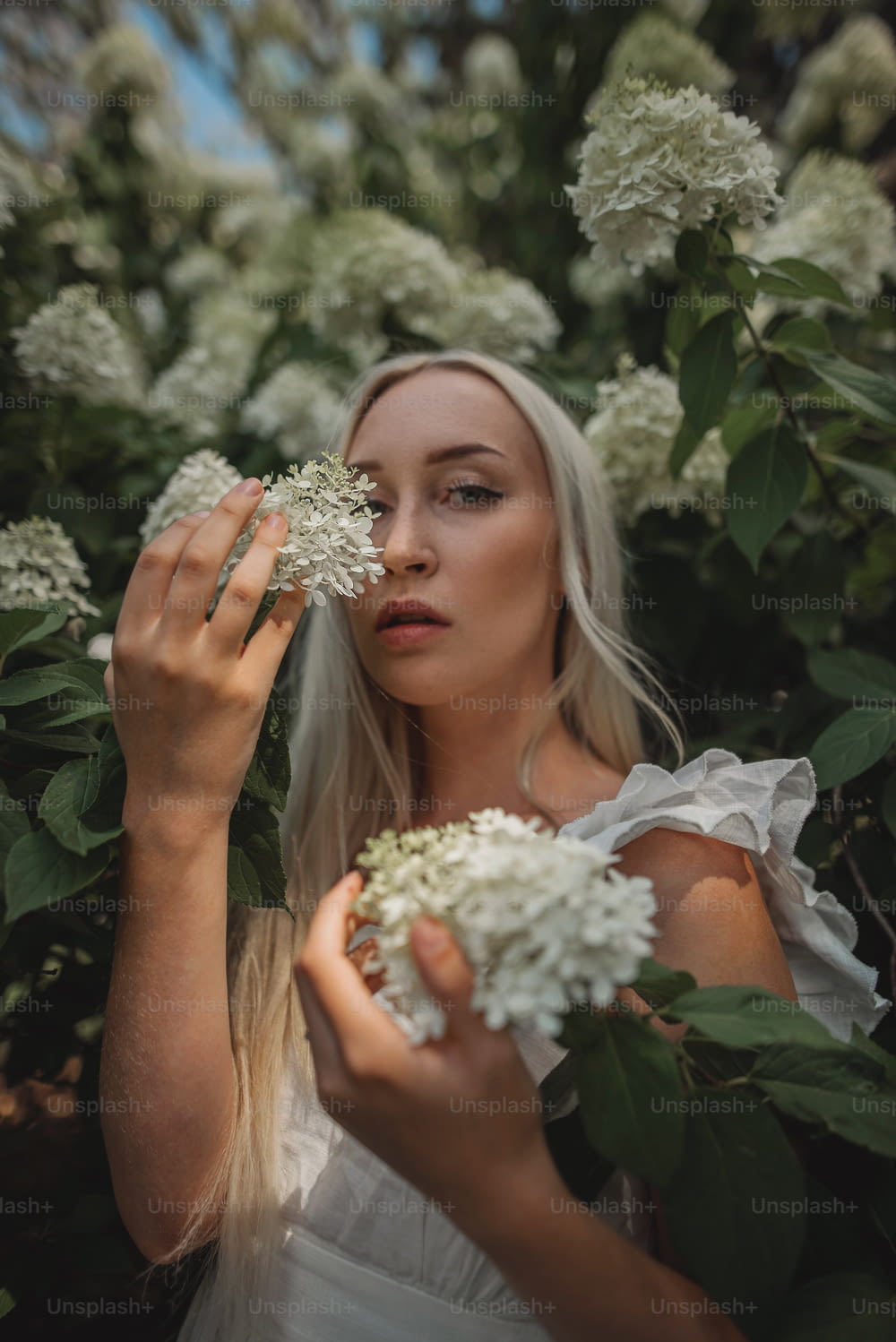 a woman holding a bunch of white flowers