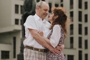 a man and a woman embracing in front of a building