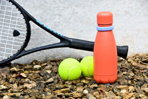 테니스 라켓과 바닥에 두 개의 테니스 공