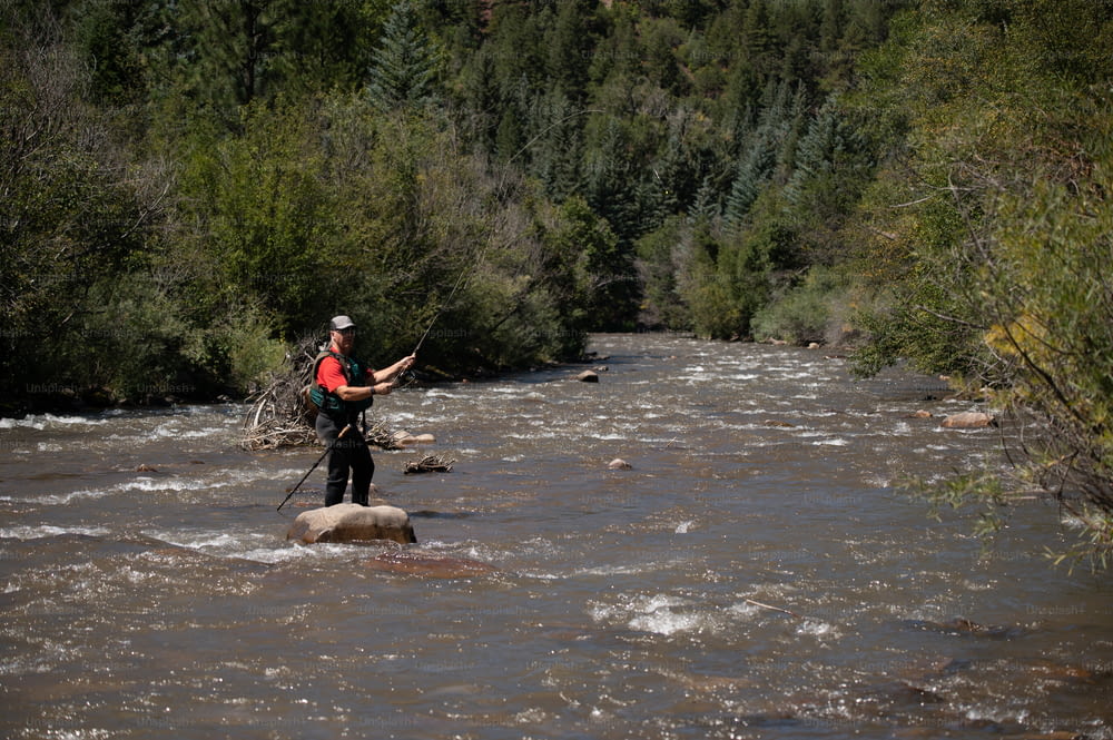 a man standing on a rock in the middle of a river