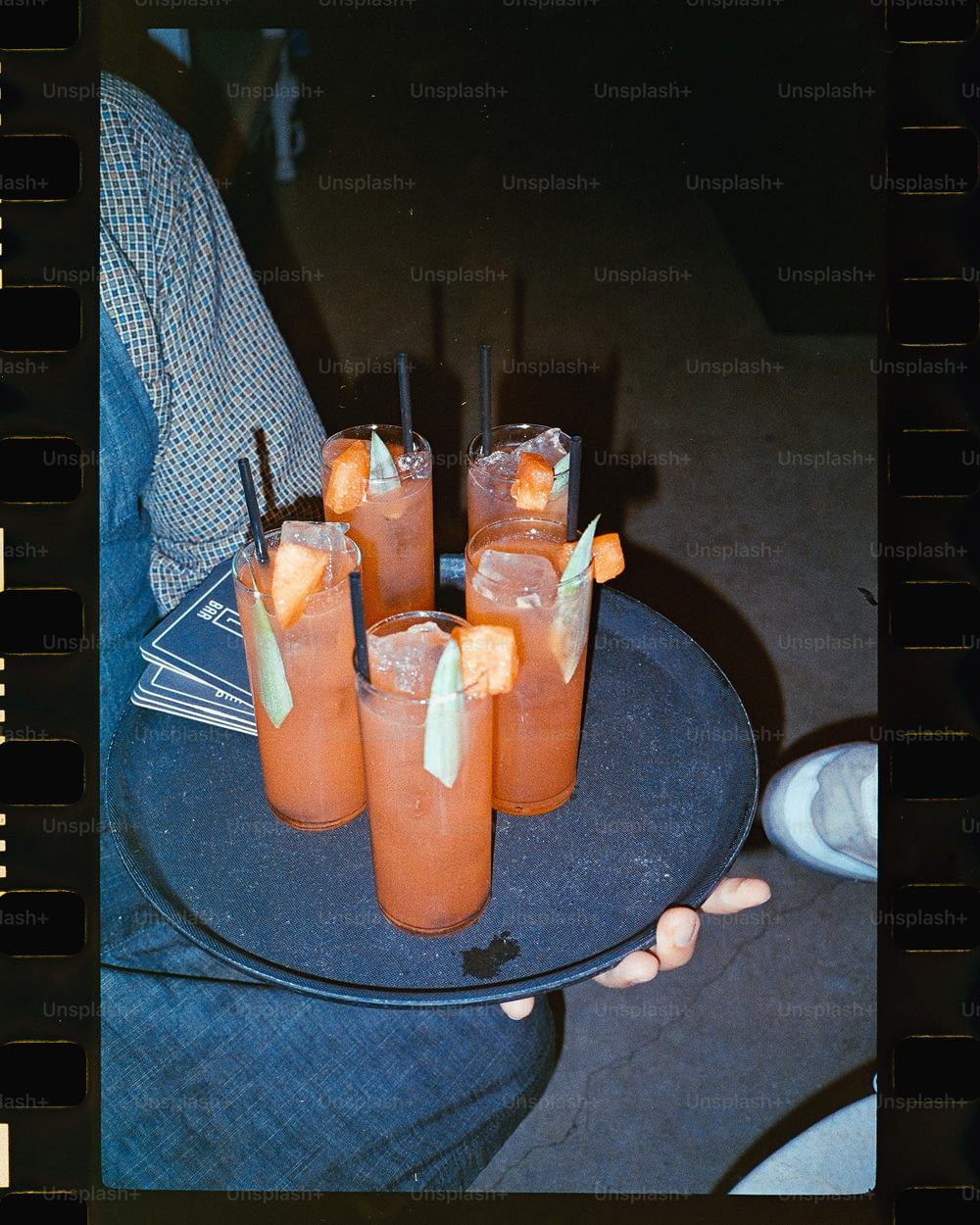a person holding a tray of drinks on a table