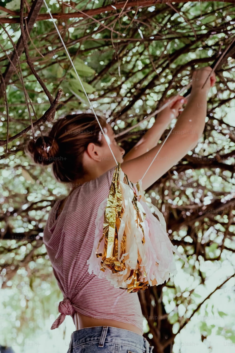 a woman in a pink shirt is hanging from a tree