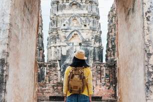 La donna turista asiatica scatta una foto dell'antica architettura tailandese del tempio della pagoda a Sukhothai, Tailandia. Viaggiatrice in stile tailandese casual che visita il concetto di città