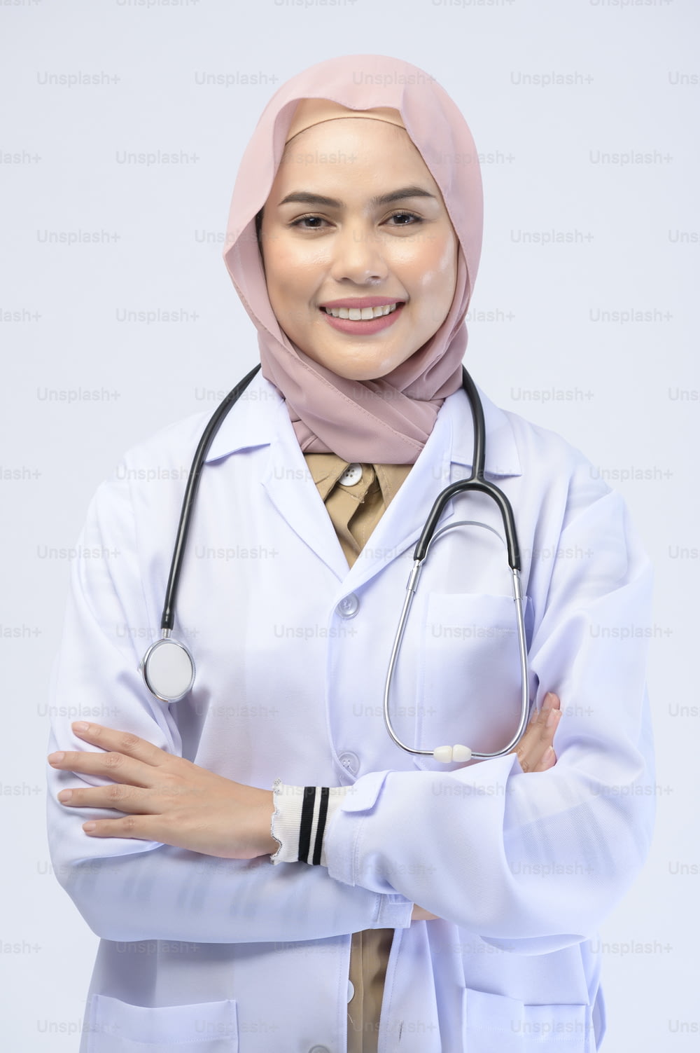 白い背景にヒジャブをかぶったイスラム教徒の女性医師。