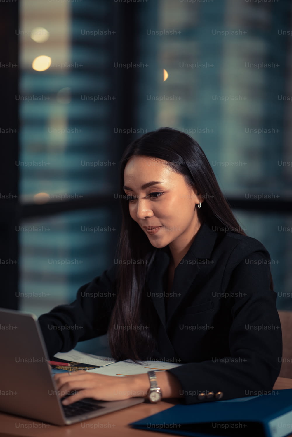 Shot of a beautiful young businesswoman using laptop and doing some paperwork while working on laptop