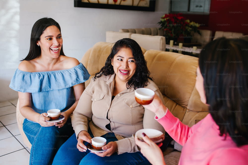 Ragazze latine che si divertono a casa, ridono e bevono caffè a Città del Messico