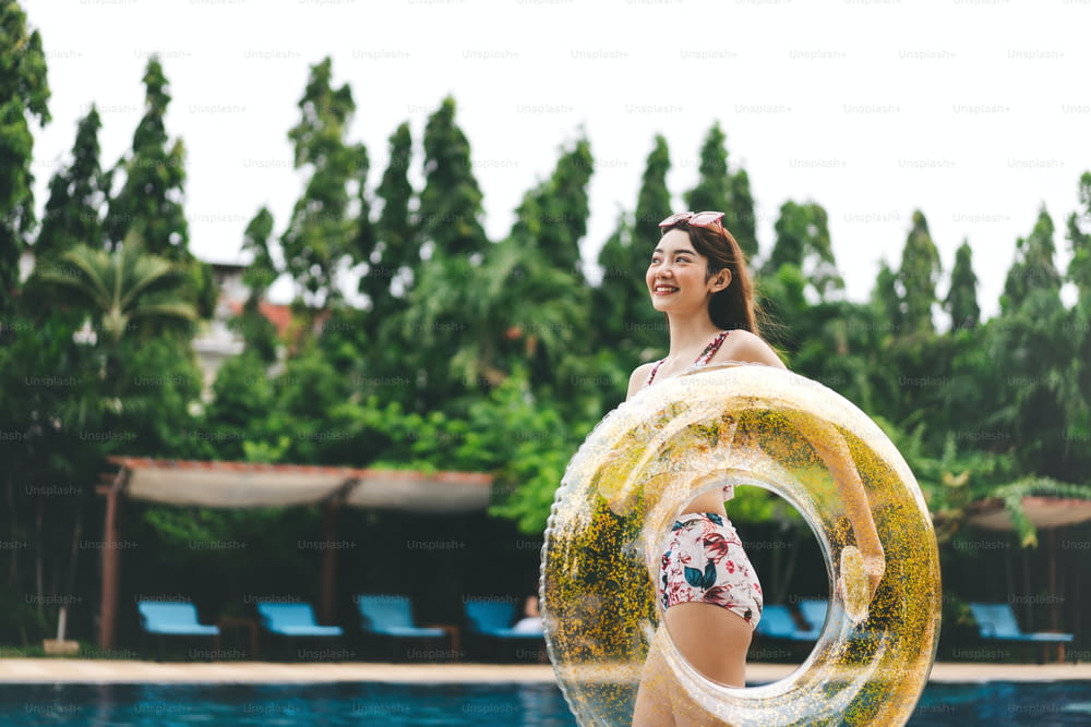 Concept de voyage d’été de vacances en Asie du Sud-Est. Sourire heureux jeune adulte femme asiatique à la piscine de l’hôtel. Les gens avec satisfaction moment de vie à la nature en plein air.