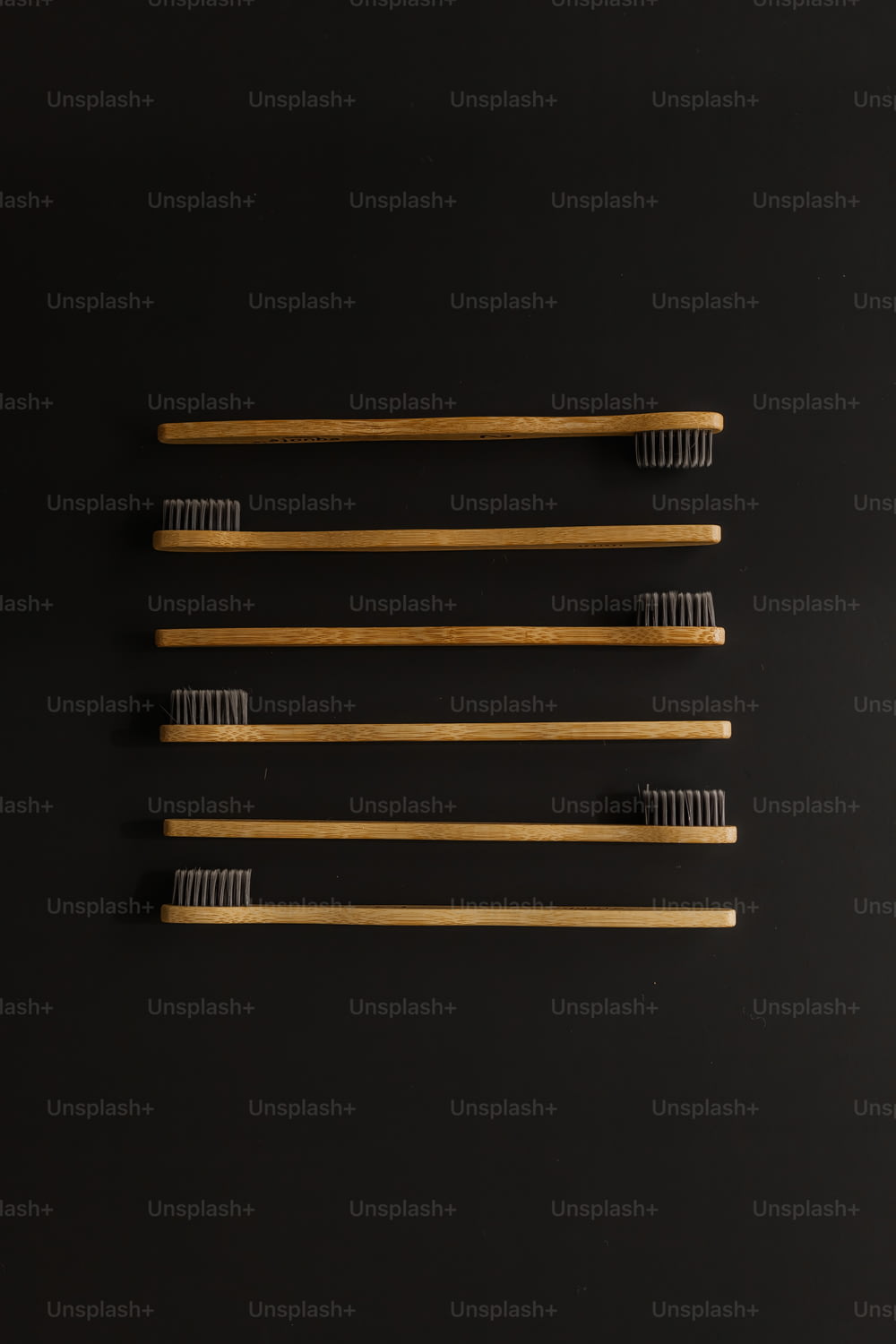 four toothbrushes lined up on a black surface