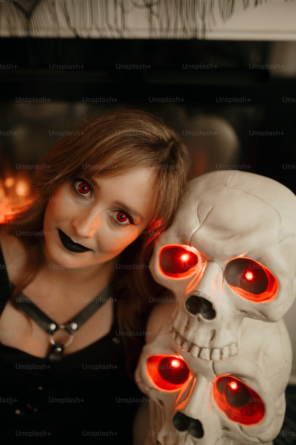 a woman holding a fake skull with glowing eyes