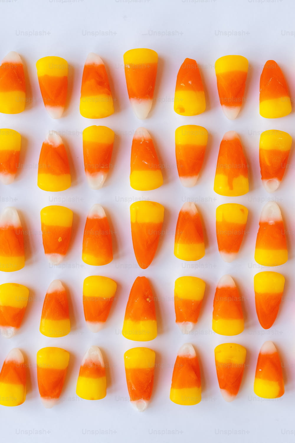 a close up of candy corn on a white surface