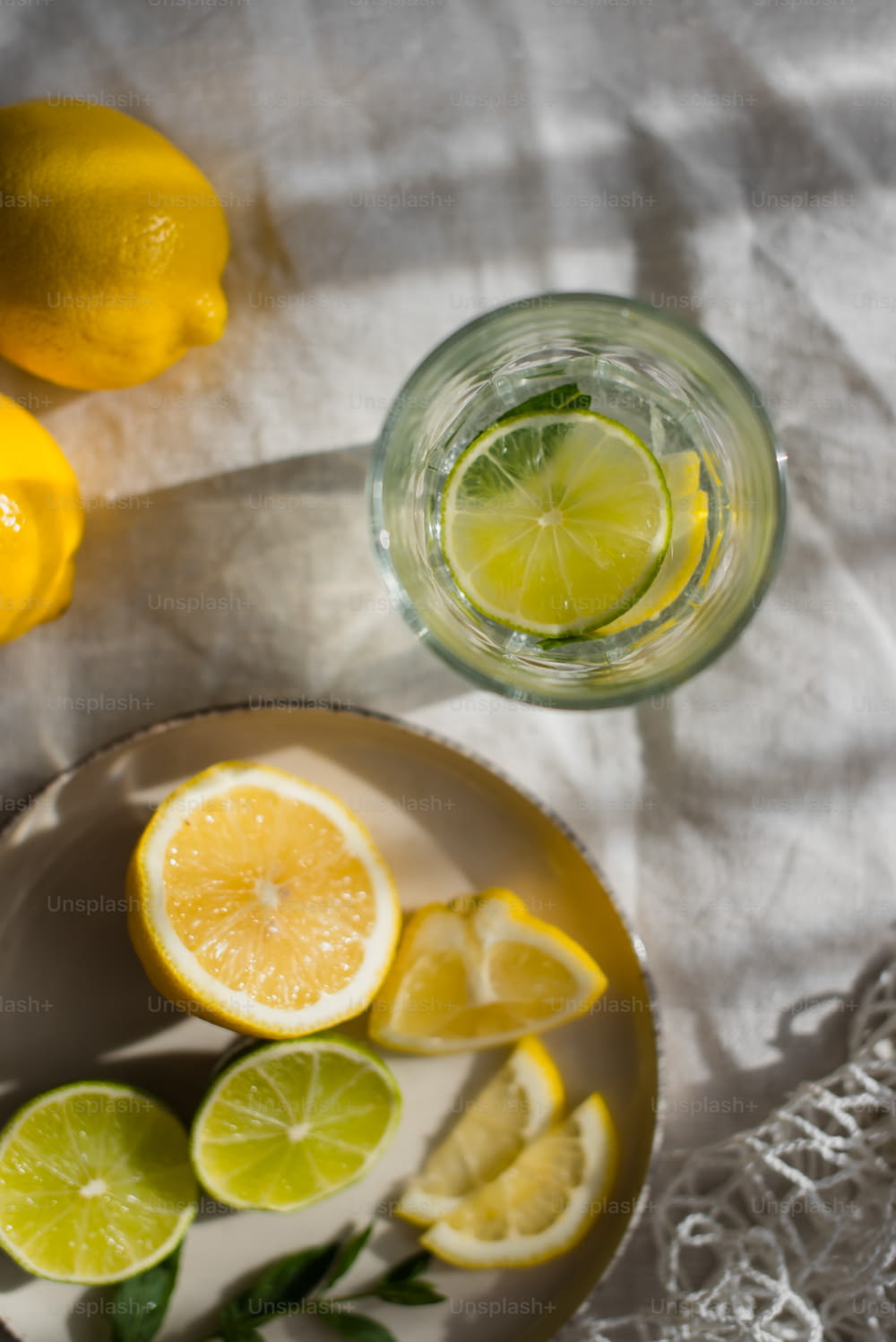 un tazón de limones y un vaso de agua