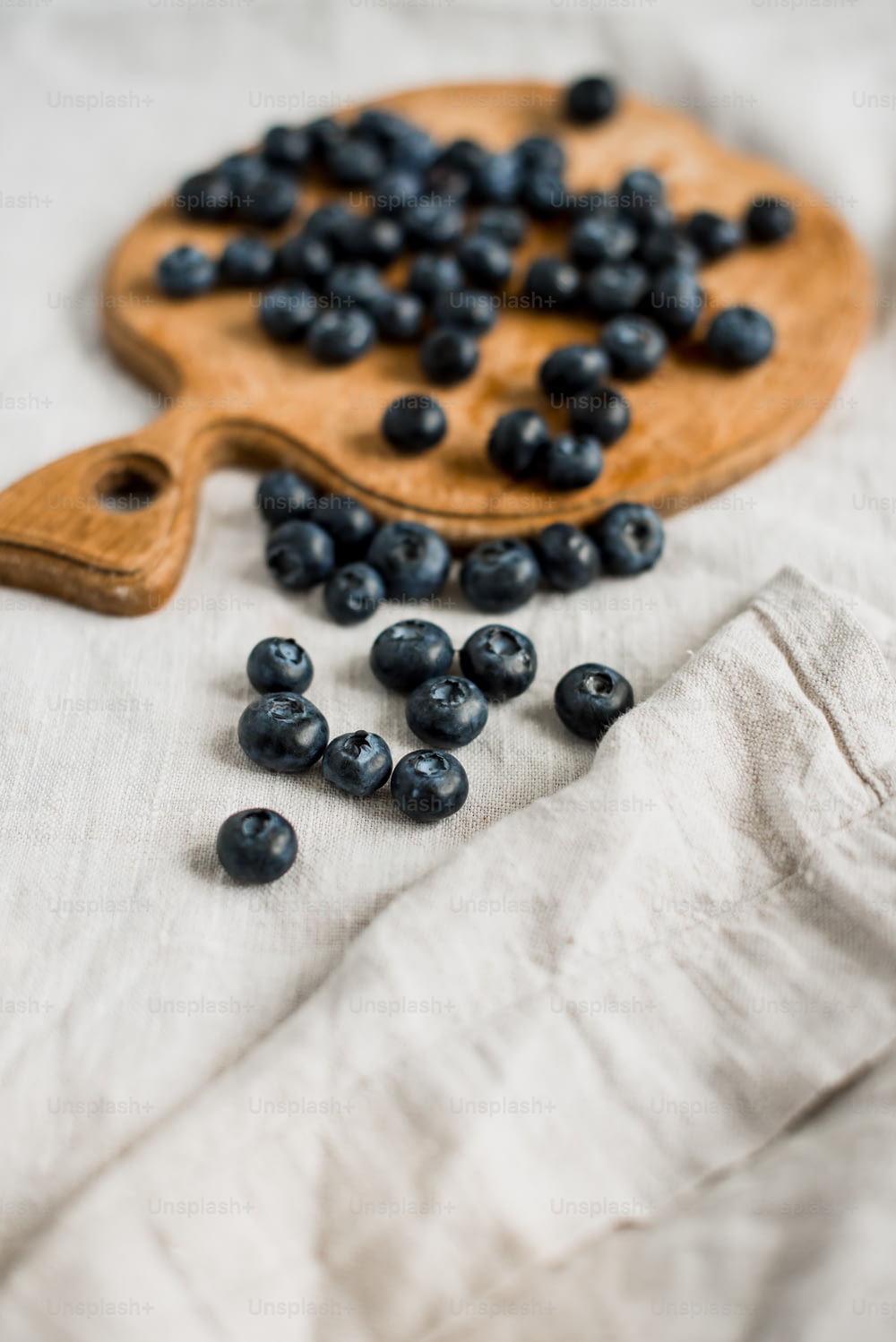 a wooden cutting board with blueberries on it