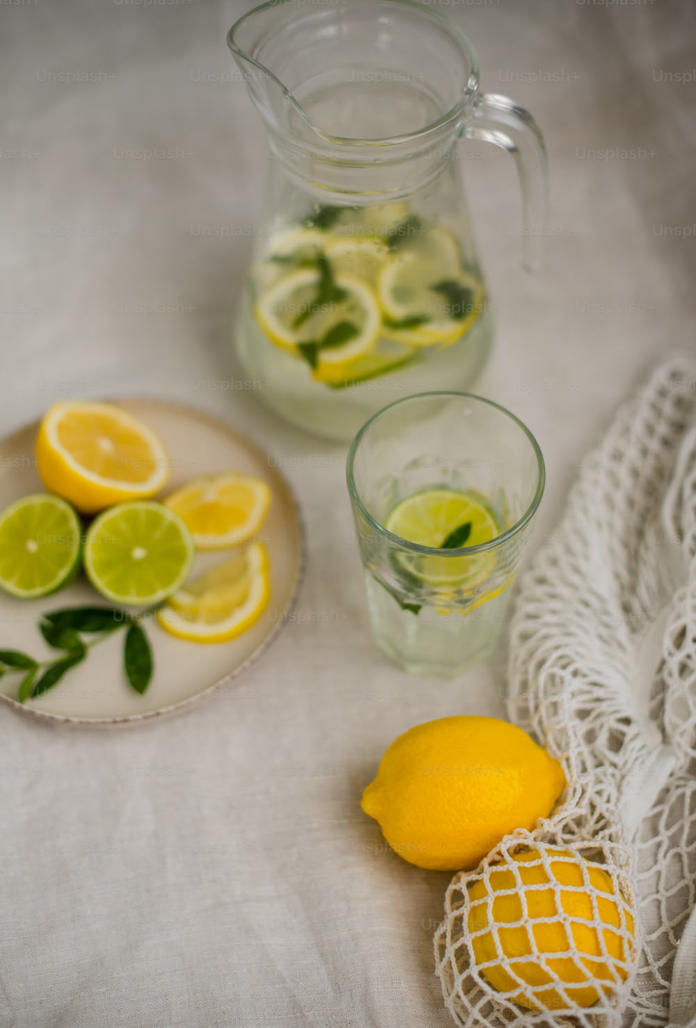 a plate of lemons and a pitcher of water