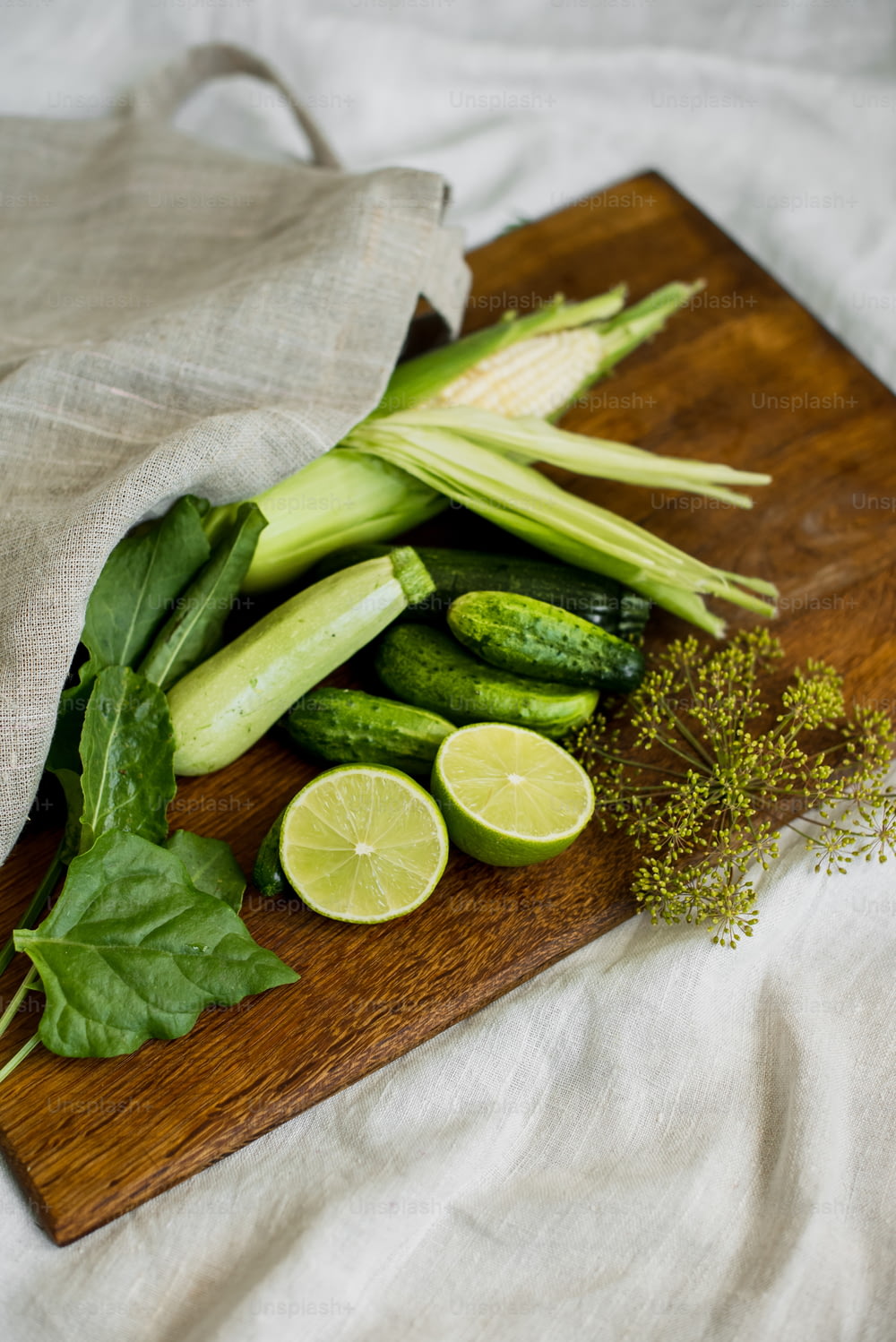 una tabla de cortar de madera cubierta con verduras verdes