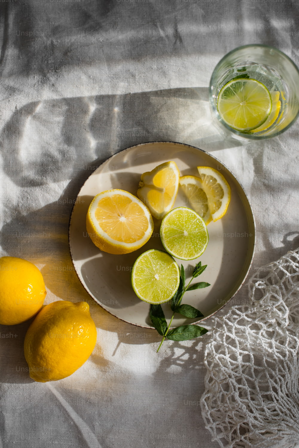 물 한 잔 옆에 레몬을 얹은 하얀 접시