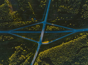 an aerial view of a road intersection in the middle of a forest