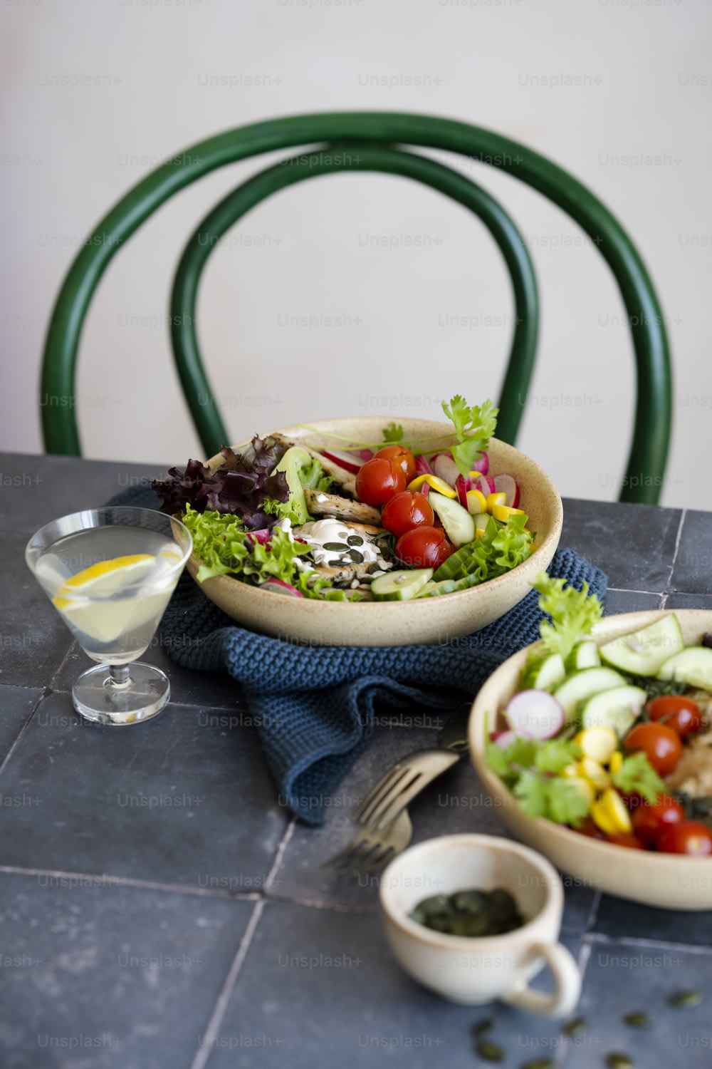 uma mesa com uma tigela de salada e um copo de vinho