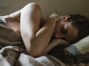 Une femme allongée dans son lit avec sa tête sur son oreiller