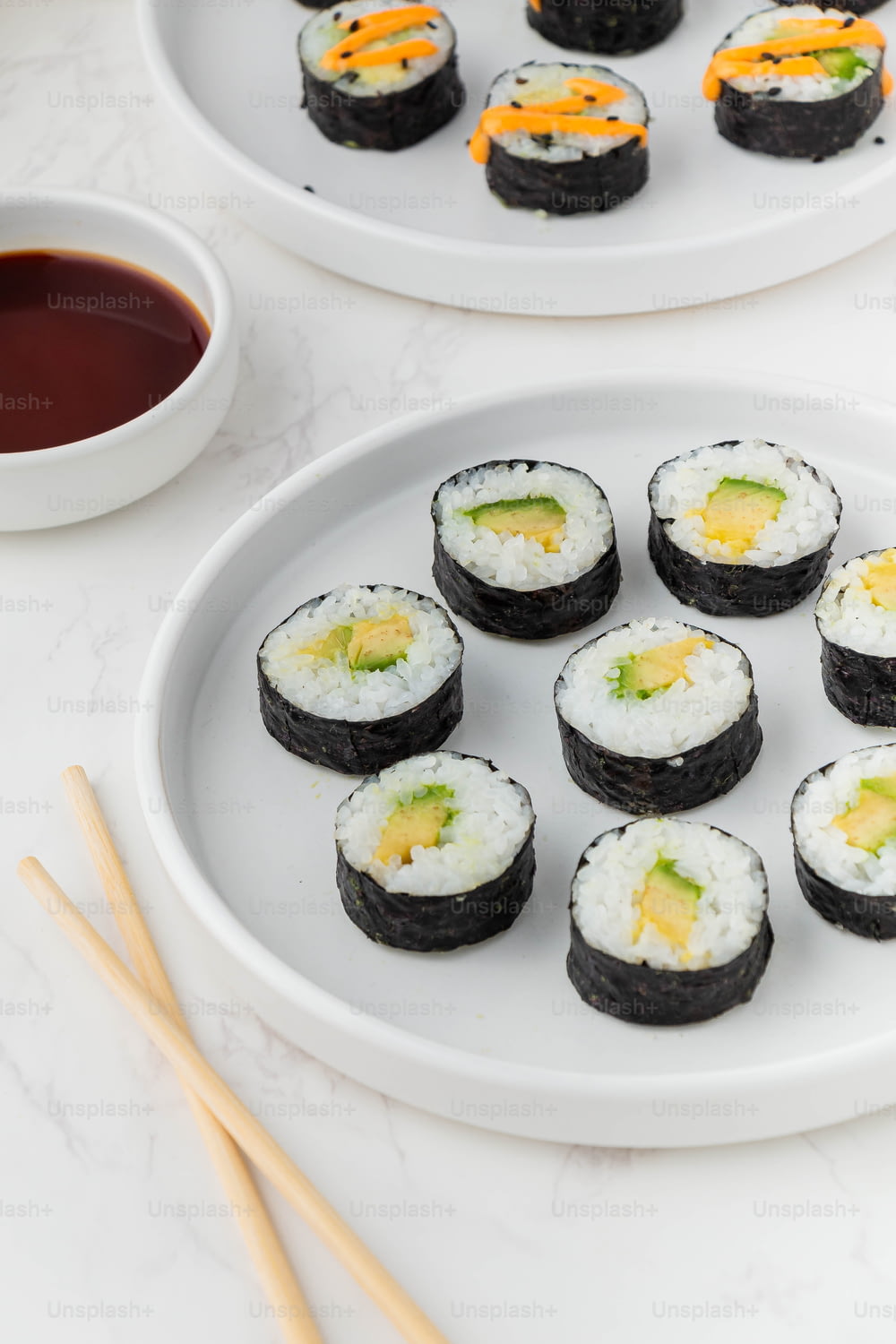 une assiette de sushis avec des baguettes à côté