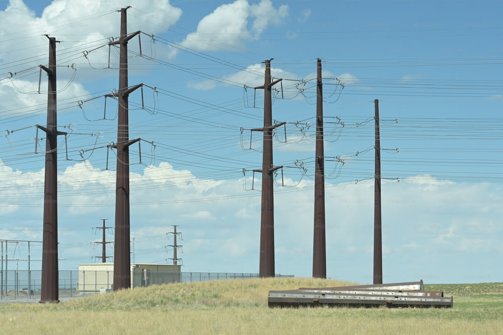 un campo de hierba con postes de teléfono y un tren en las vías