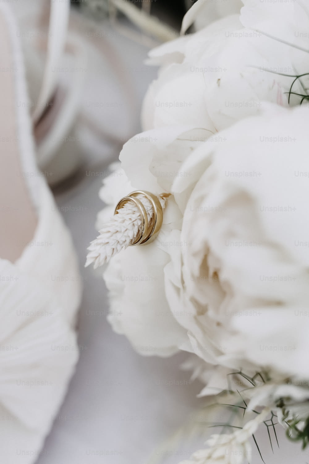 un bouquet de fleurs blanches assis à côté d’une paire de chaussures