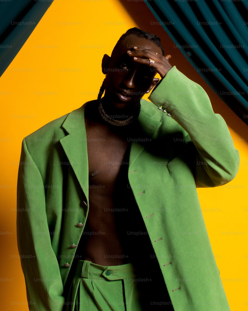 a man in a green suit is covering his eyes